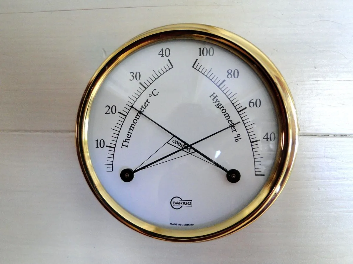 Thermomètre et hygromètre d'intérieur à aiguilles fixé sur un mur blanc
